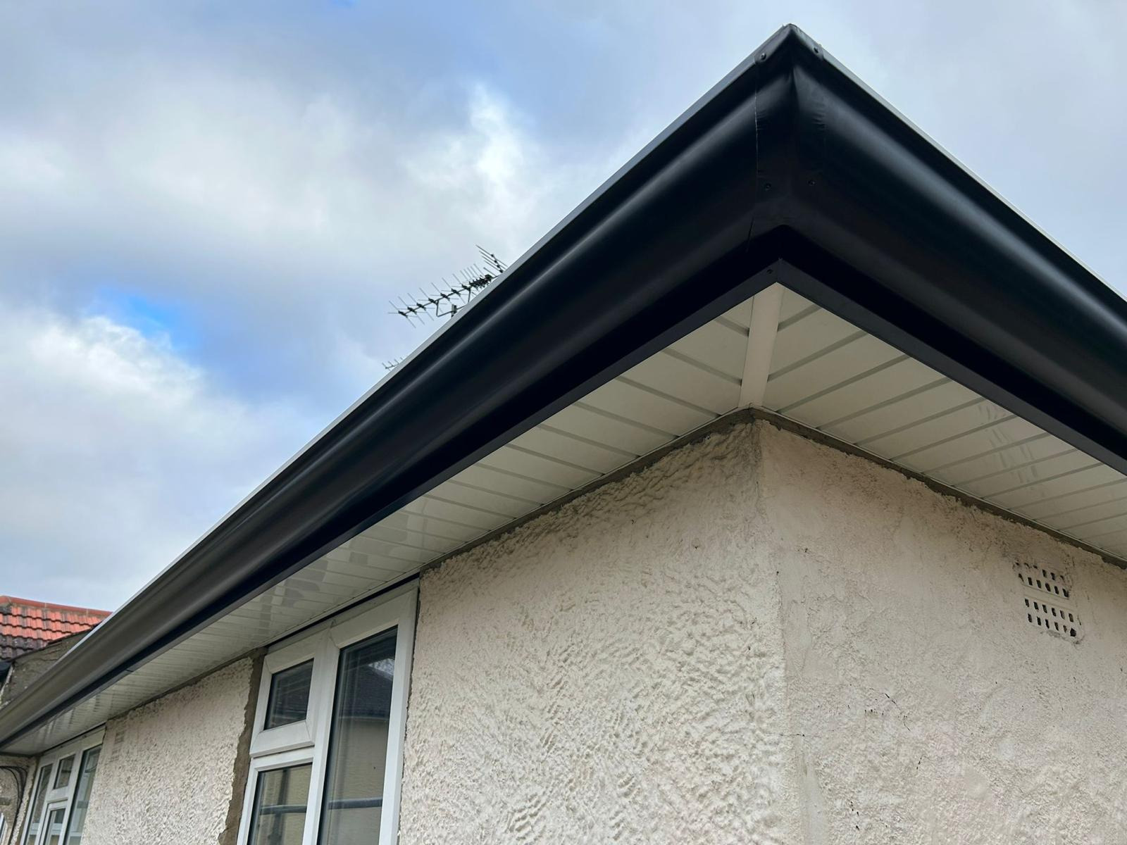 Seamless anthracite aluminium guttering against a blue sky